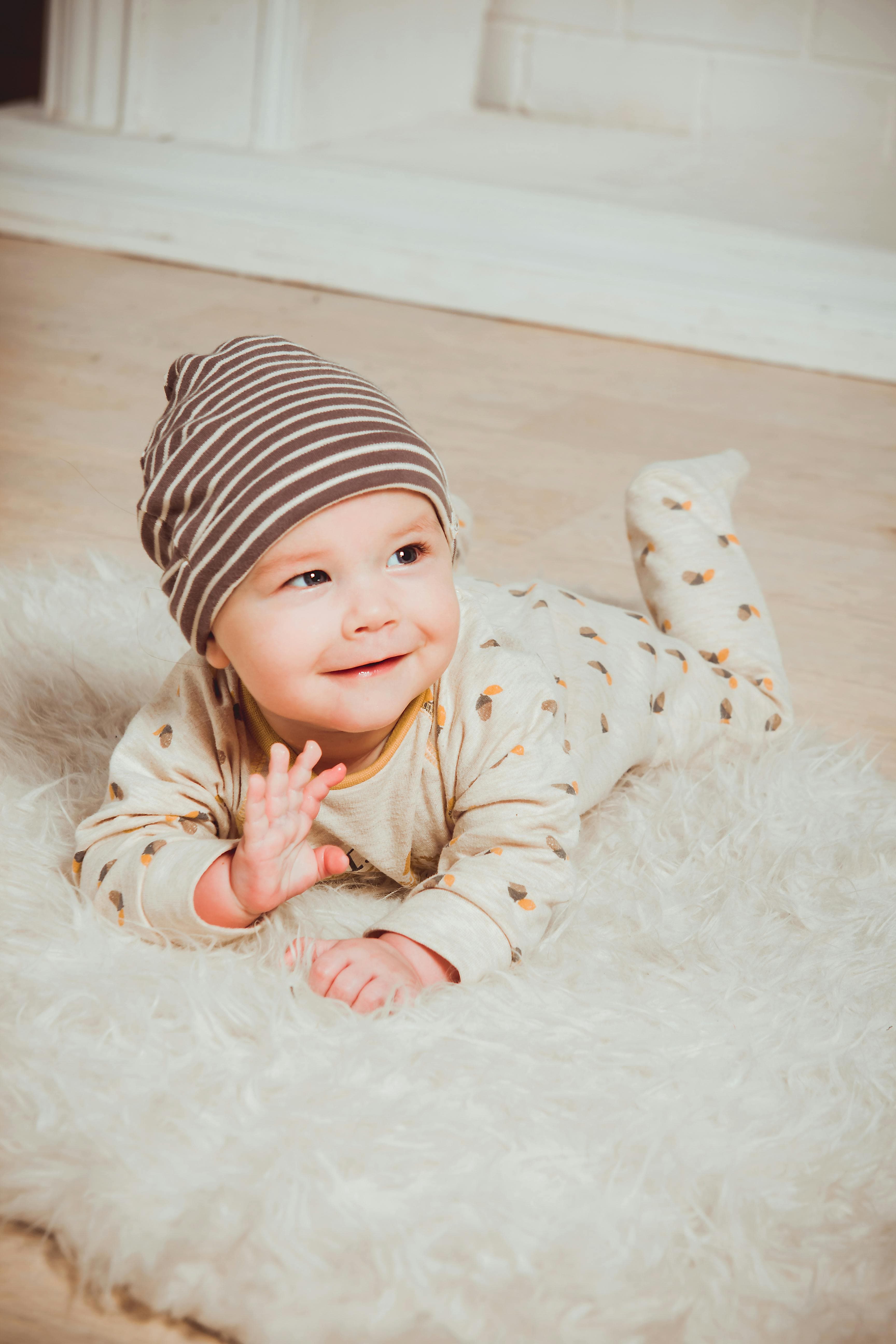 Lächelndes Baby auf einer weichen Decke, Sinnbild für Wärme und Zuwendung bei der Begleitung mit Eltrust.